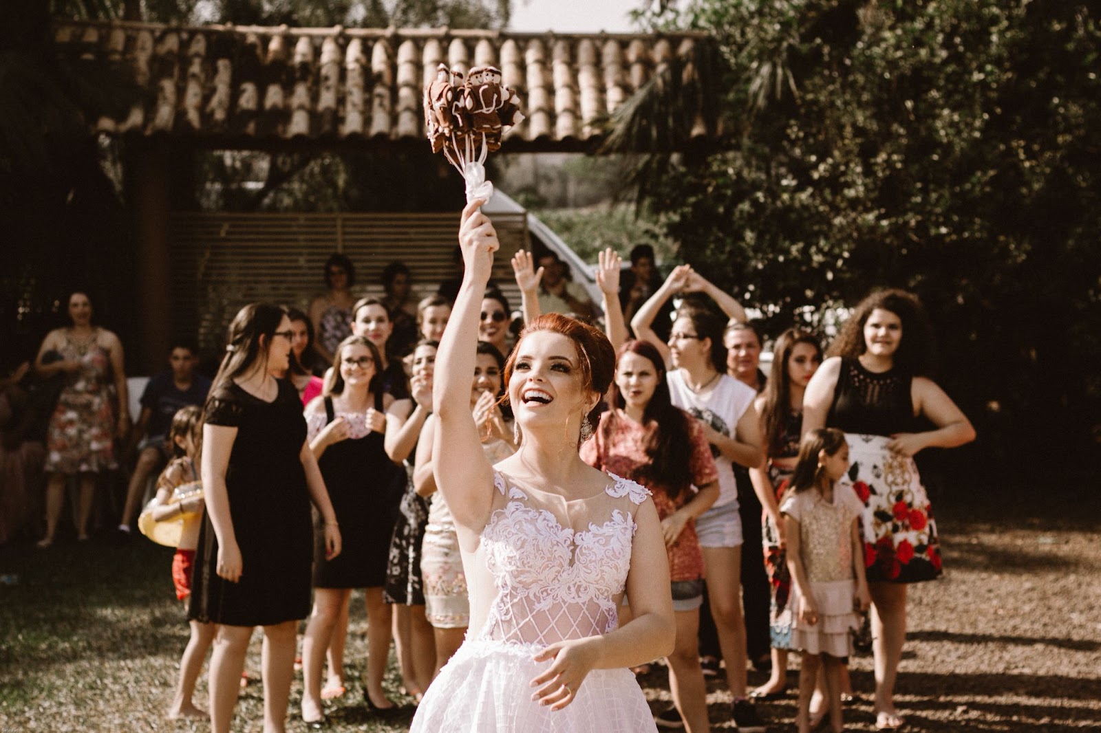 A bride tosses a bouquet of childhood dolls to the women who attended her fall ceremony