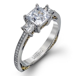 A princess cut diamond three stone ring with gold details.