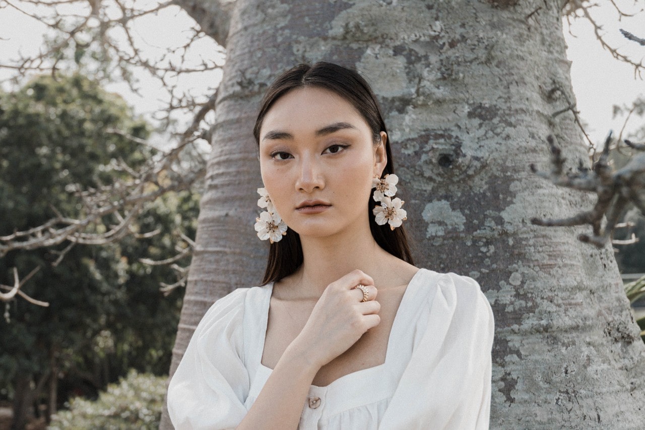 A young woman wearing elegant flower earrings