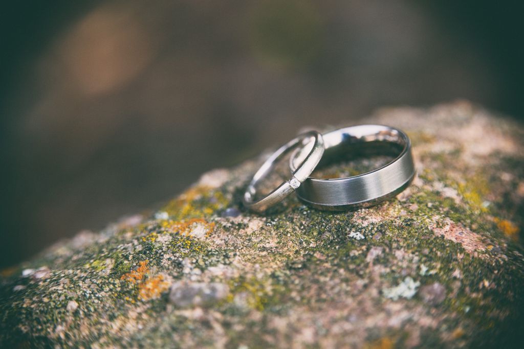 Two simple yet elegant wedding bands displayed on a colorful stone.